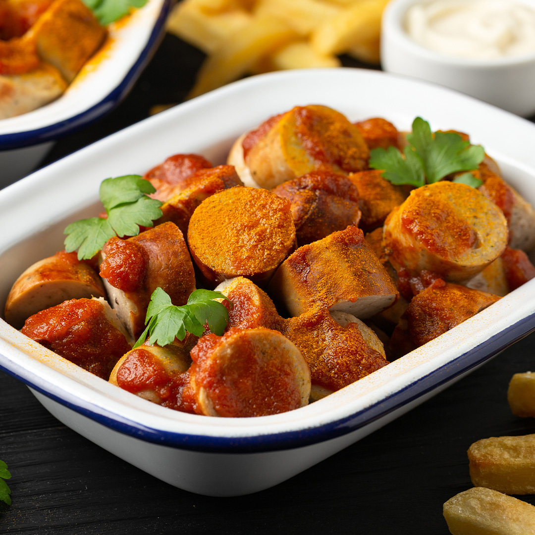 Le plat traditionnel allemand, la Currywurst, accompagné de chips et de sauce.