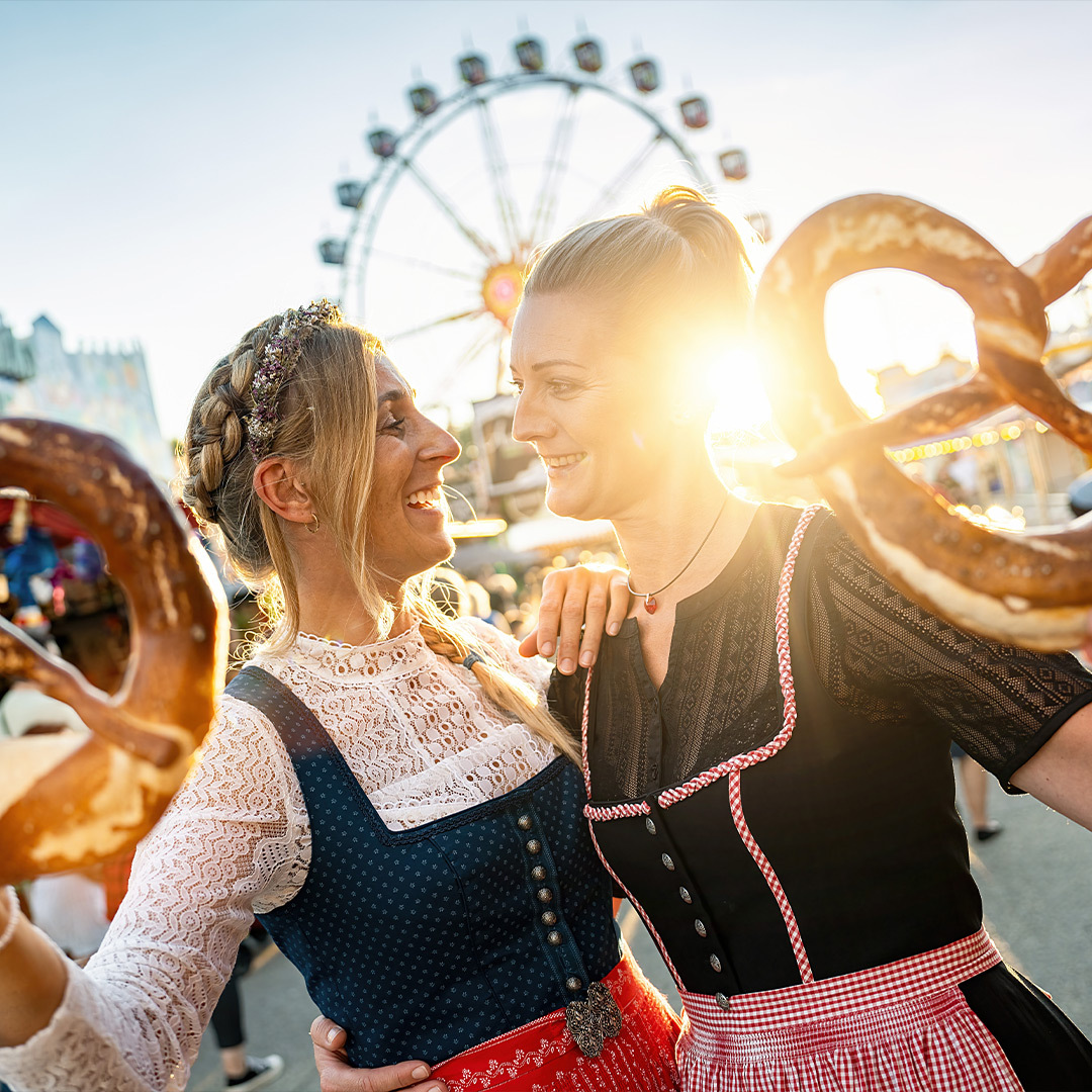 Deux femmes célébrant l’Oktoberfest, bretzels à la main.