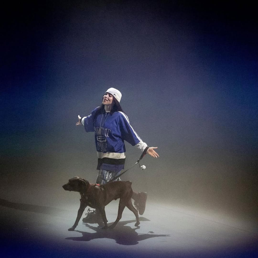 Billie Eilish sur scène avec un chien.