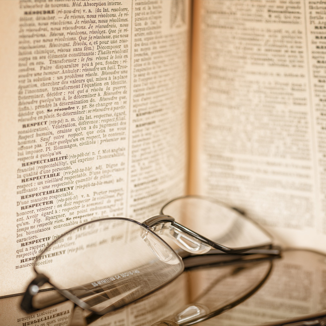 Dictionnaire Larousse avec une paire de lunettes en avant-plan.