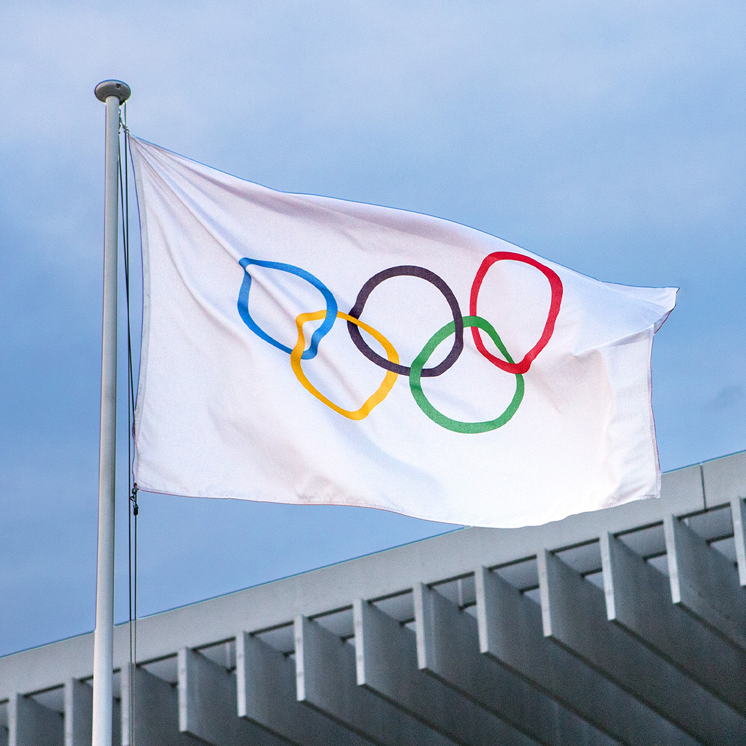 Un drapeau des anneaux olympiques au vent.