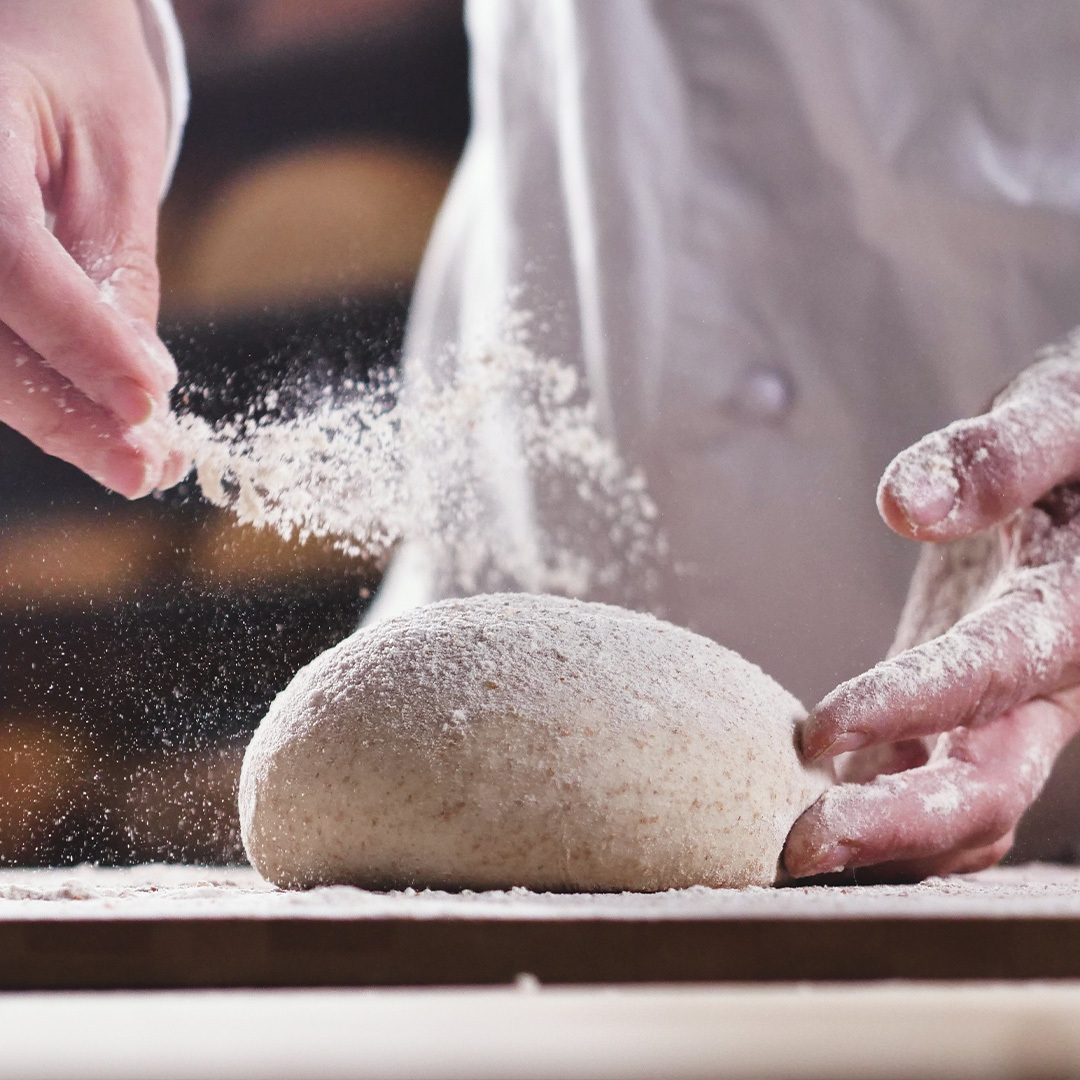 Un chef prépare la pâte avec de la farine.