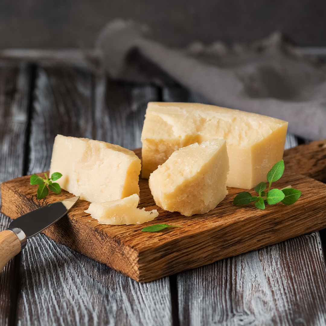 Fromages parmesan sur plateau de bois.