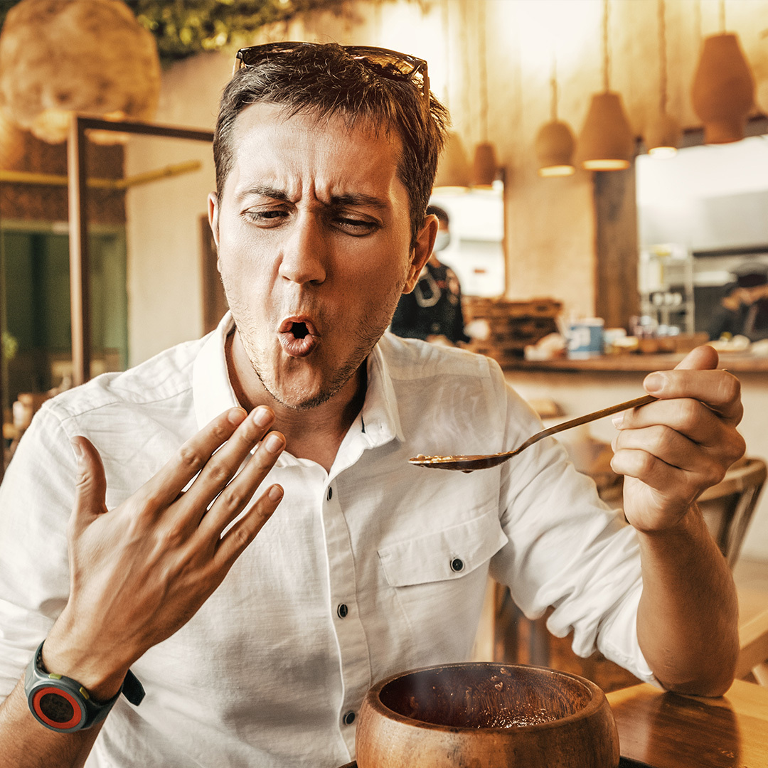 Un homme mangeant un plat épicé.