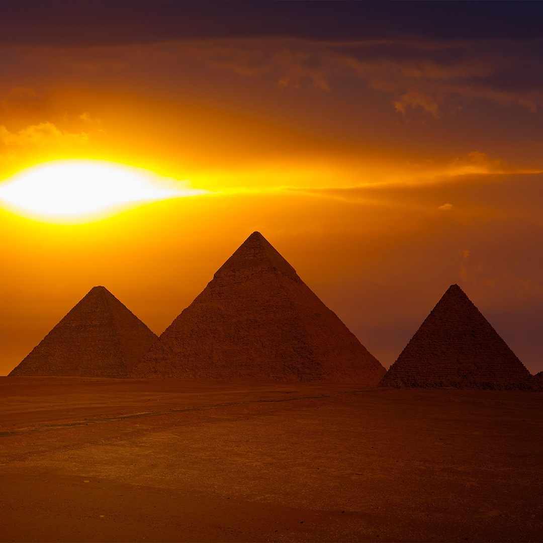 Le soleil se couche sur les pyramides de Gizeh.