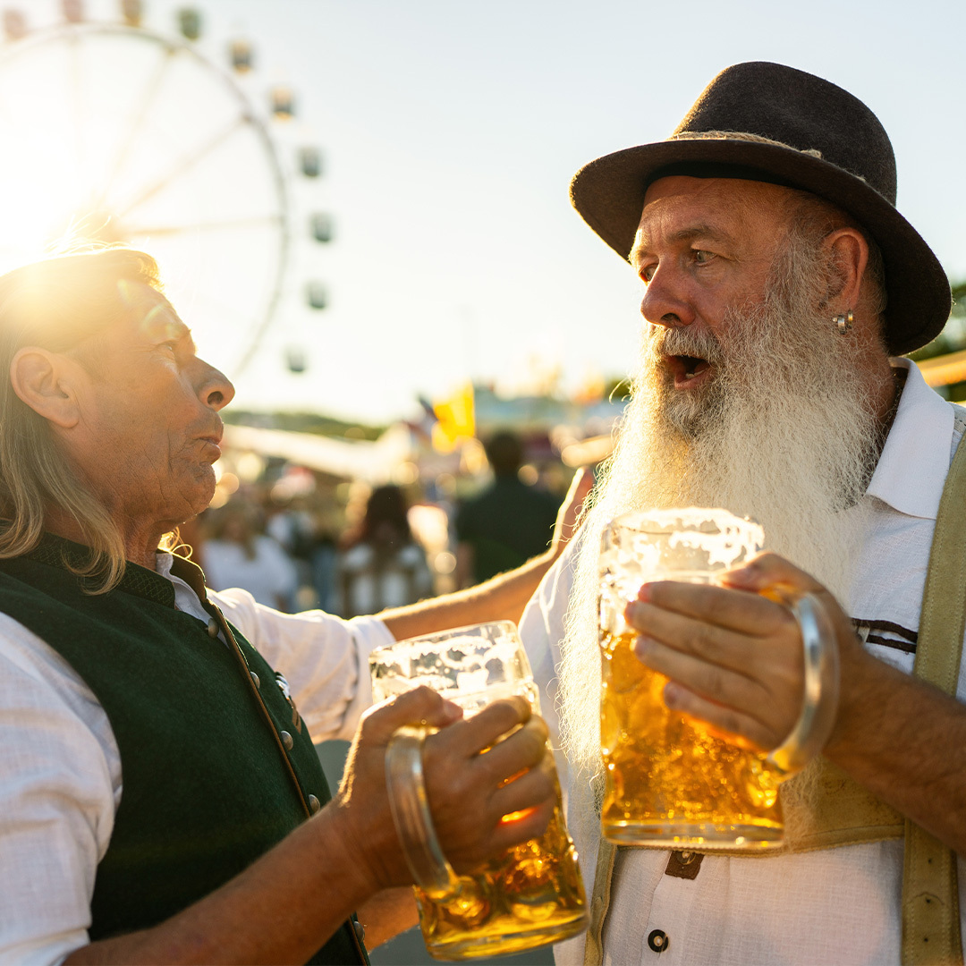 Deux hommes célèbrent l’Oktoberfest, chopes de bière à la main.
