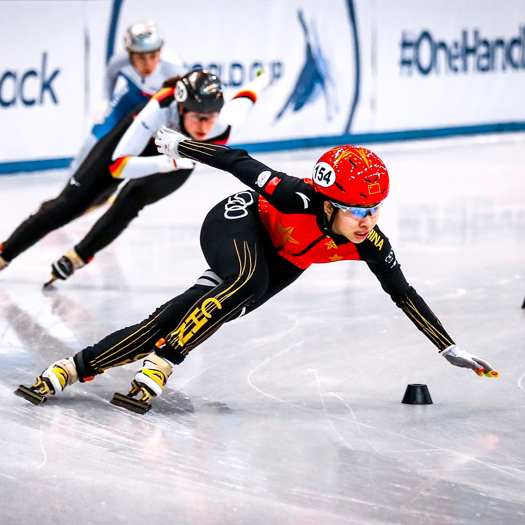 Three short-track speed skaters in competition.