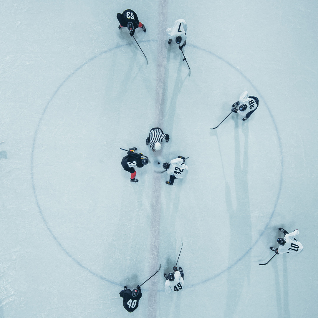 View from above of a hockey game with players facing off at centre ice.