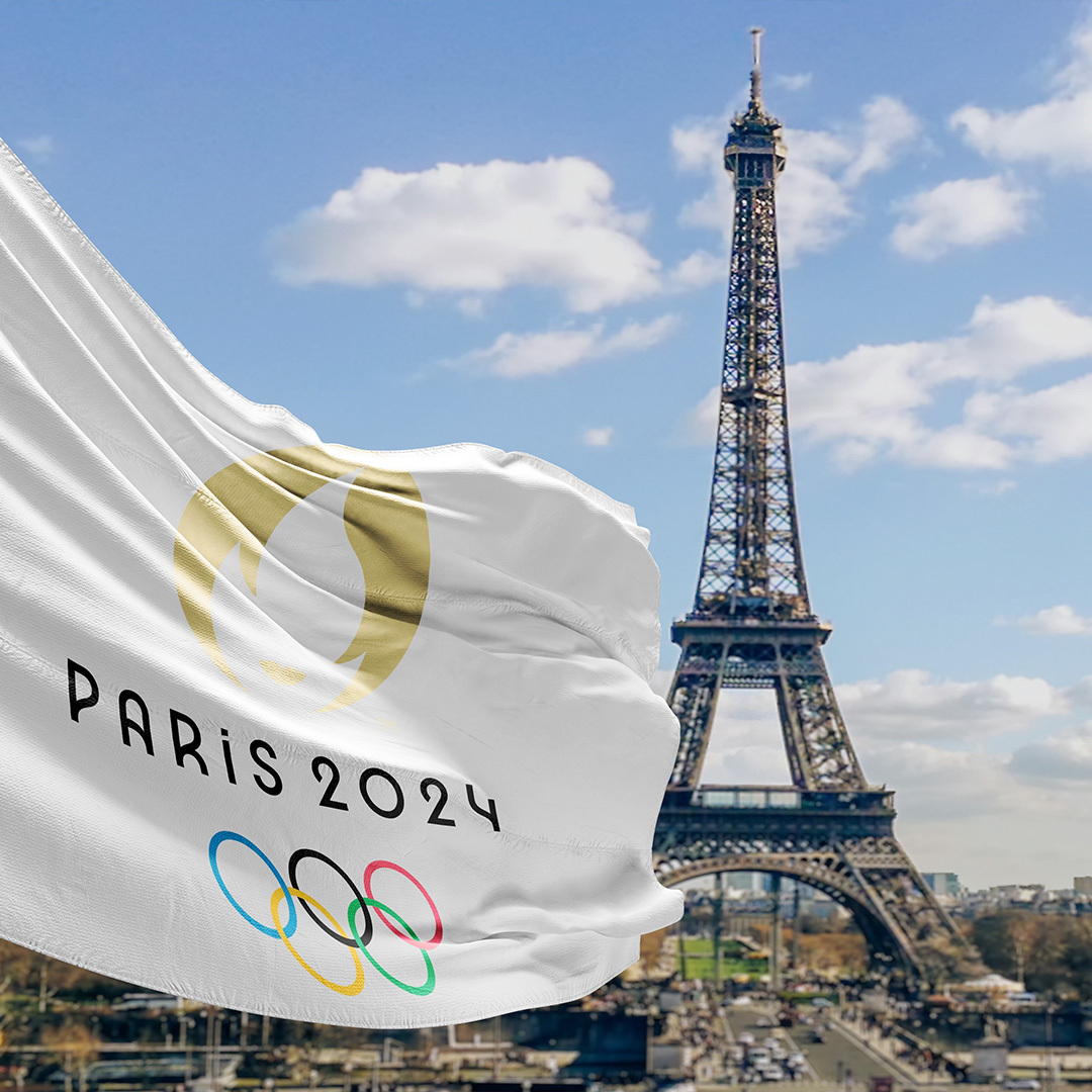 Drapeau des Jeux olympiques de Paris en 2024 au vent devant la Tour Eiffel.