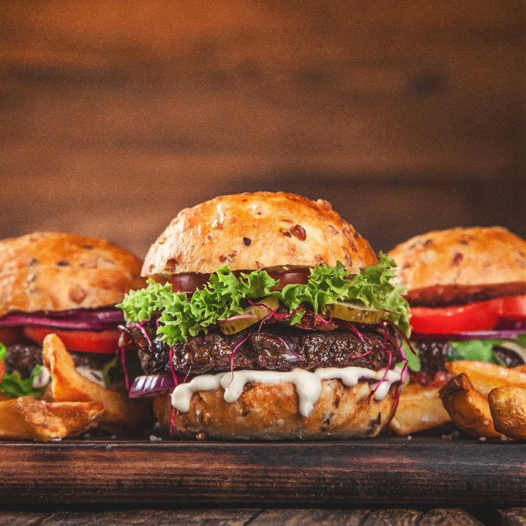 Plan rapproché de trois burgers bien garnis.