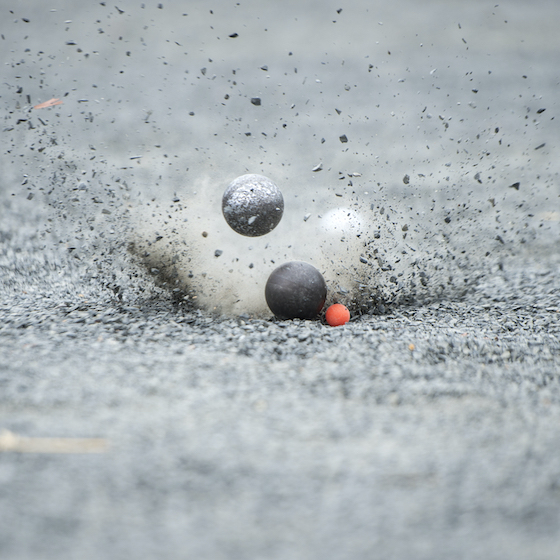 Though the surface of a pétanque court can vary, it is most often played on a level field covered in gravel. 